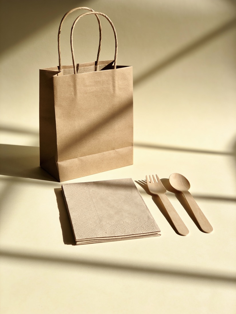 Papieren draagtas, servetten en houten vork en lepel